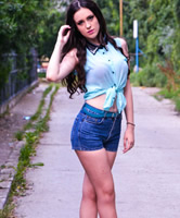 Straßenfoto von brünetter Hübscher mit langen Beinen