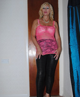 Reife Blonde trägt pinkes Oberteil und schwarze Tights