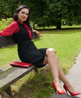 Stiletto Girl Maria, brünett, trägt rote Heels in der Mittagspause