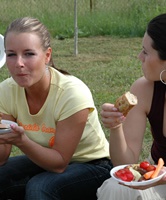 Unschuldige und süße junge Freundinnen grillen in der Freizeit zusammen